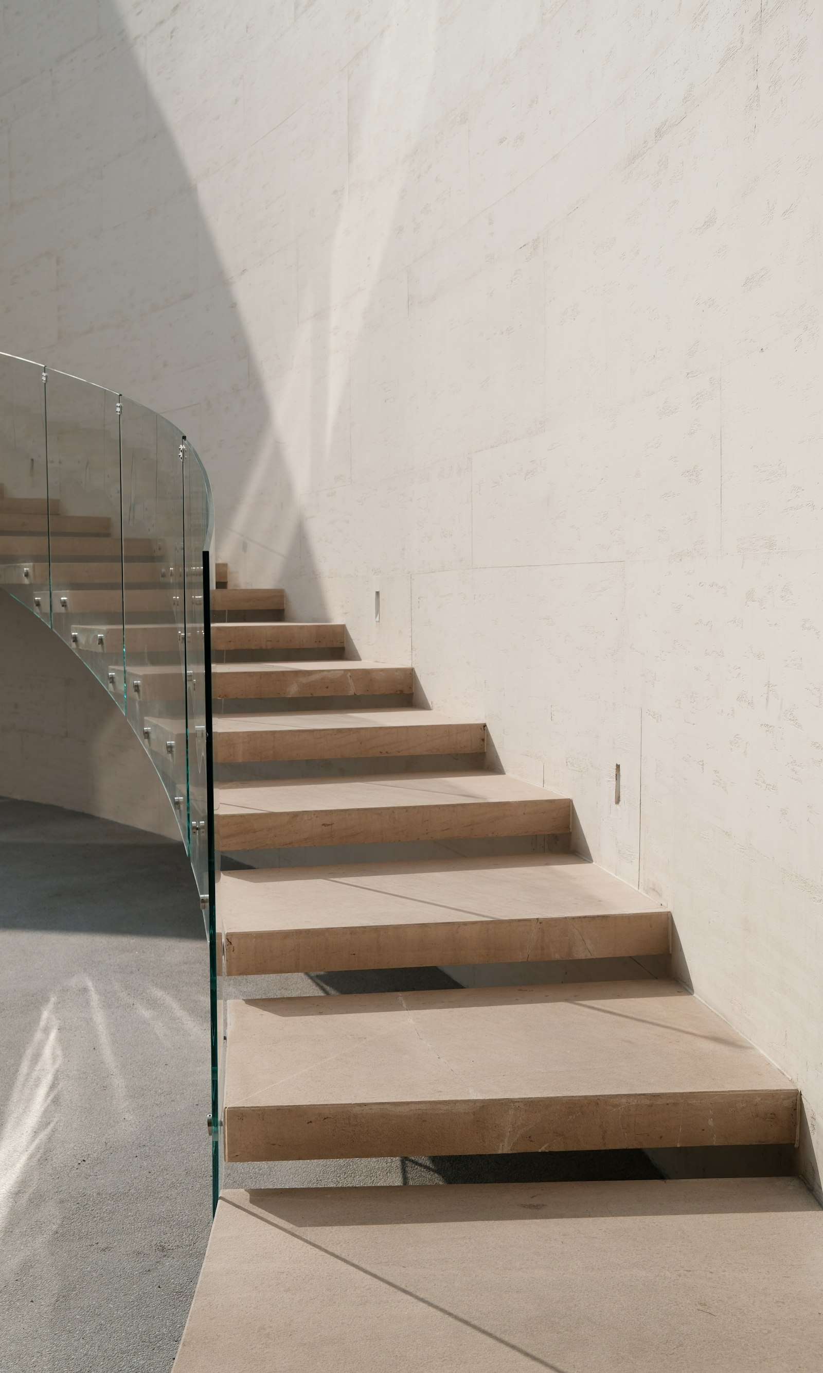 Open staircase with a transparent side railing — the sightline an invisible cable railing preserves along a stair edge